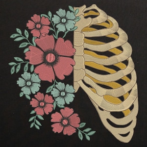 May include: Embroidered design featuring a stylised ribcage with floral accents. The ribcage is beige with yellow stitching, and the flowers are pink, red, and blue.