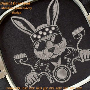 May include: Digital download machine embroidery design featuring a biker rabbit wearing sunglasses and a studded headband, riding a motorcycle. The design is in shades of gray on a black background. The text "Digital Download Machine Embroidery design" is at the top.