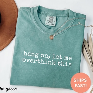 May include: Light green t-shirt with the text "hang on, let me overthink this" printed in white.
