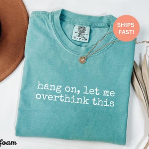 May include: Seafoam green t-shirt with the text "hang on, let me overthink this" printed in white.
