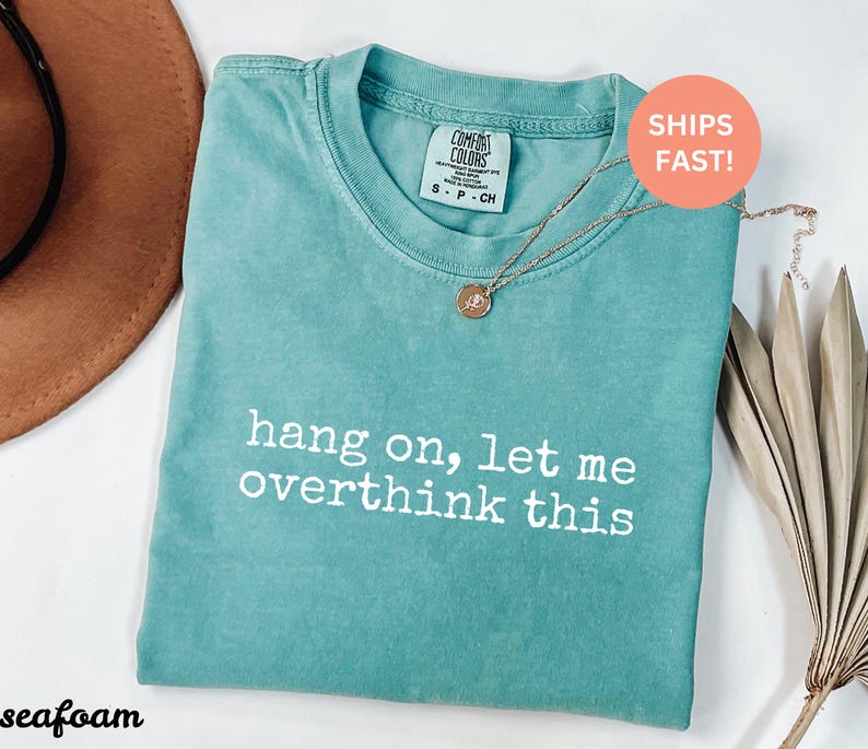 May include: Seafoam green t-shirt with the text "hang on, let me overthink this" printed in white.
