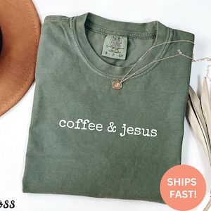 May include: A green t-shirt with the text "coffee & jesus" in white lettering. The shirt is made of a soft, comfortable material and has a relaxed fit.