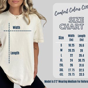 May include: A cream-colored t-shirt with a size chart and the text "Comfort Colors C1717." The size chart shows measurements in inches for width and length, ranging from size small to 4XL. The model is 5'2" and wearing a medium.