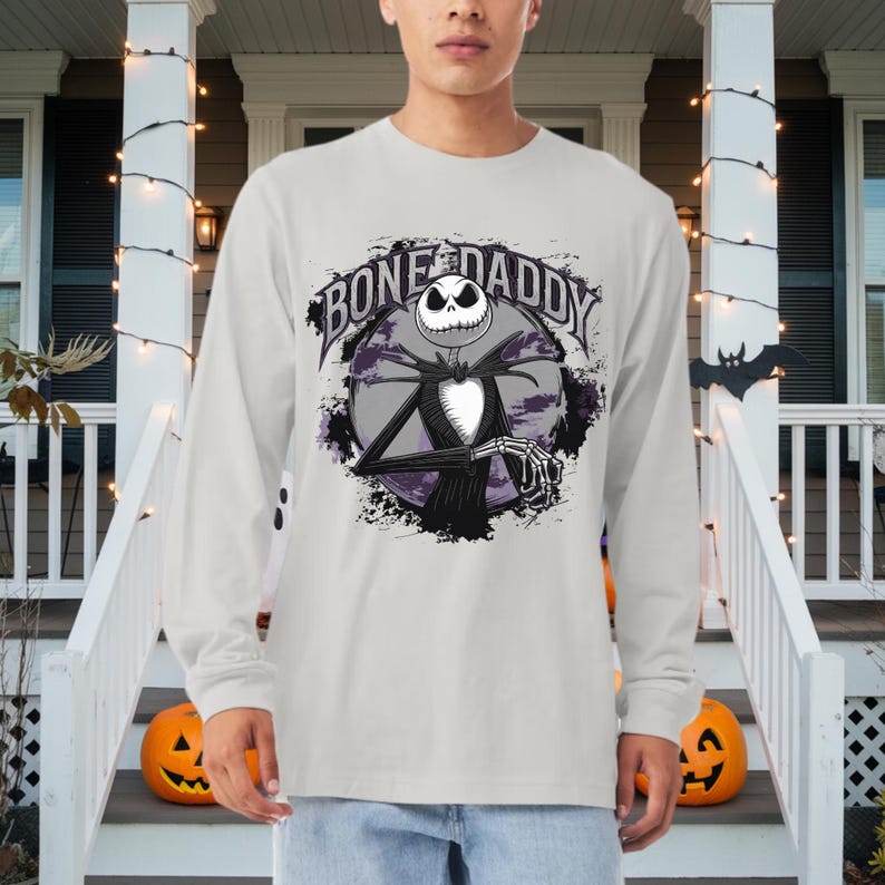 Może przedstawiać: Szary T-shirt z długim rękawem z grafiką Jacka Skellingtona z filmu Koszmar przed świętami. Grafika zawiera tekst "Bone Daddy".