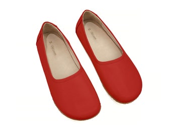 Könnte beinhalten: Ein Paar rote Ballerinas mit schlichtem Design. Die Ballerinas haben eine abgerundete Spitze und eine flache Sohle.