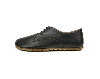 May include: Black leather lace-up shoes with a brown stitched sole.