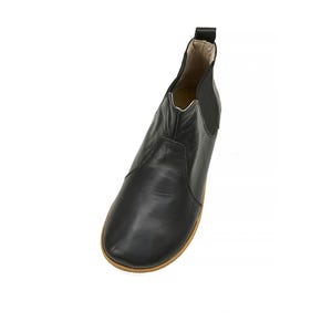 K&ouml;nnte beinhalten: Schwarze Lederstiefeletten mit abgerundeter Spitze und elastischen Seitenteilen. Die Stiefeletten haben eine braune Gummisohle.