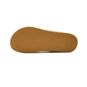May include: Close-up of the bottom of a light brown shoe with a textured sole.