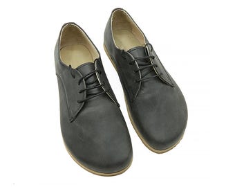 May include: A pair of black leather lace-up shoes with a rounded toe and a low heel.