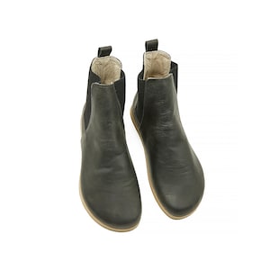May include: A pair of black leather ankle boots with elastic side panels. The boots have a rounded toe and a low heel.