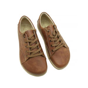 以下が含まれることがあります： 白いソールが付いた、茶色の革製のレースアップシューズのペアです。