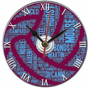 Op de afbeelding: Een ronde wandklok met een bordeauxrode wijzerplaat met namen in een woordwolkontwerp. De klok heeft zwarte wijzers, een rode secondewijzer en Romeinse cijfers. Het ontwerp bevat de tekst "The Hammers".