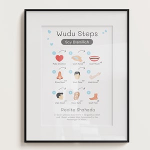 May include: A framed print with a white mount and black frame. The print displays the words "Wudu Steps" and illustrations of ablution steps. The text "Say Bismillah" is above the illustrations. The bottom of the print reads "Recite Shahada".