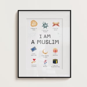 May include: Framed art print with a black border, featuring the text "I AM A MUSLIM" and illustrated icons representing Islamic beliefs and practices. The print includes phrases like "I believe in Allah" and "I pray every day."