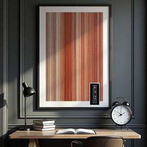 Op de afbeelding: Een ingelijste verticale wandkunstprint met een patroon van dunne, parallelle strepen in verschillende tinten rood, oranje en crème. Een klein zwart rechthoekig label in de rechterbenedenhoek bevat de witte Japanse tekst ルーク・ハマー.