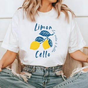 White Comfort Colors unisex shirt with yellow lemons and navy blue leaves, featuring “Limoncello” text and “La vita è bella” in script.