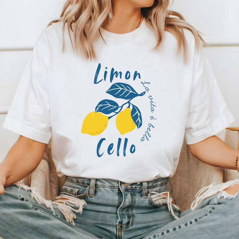 White Comfort Colors unisex shirt with yellow lemons and navy blue leaves, featuring “Limoncello” text and “La vita è bella” in script.