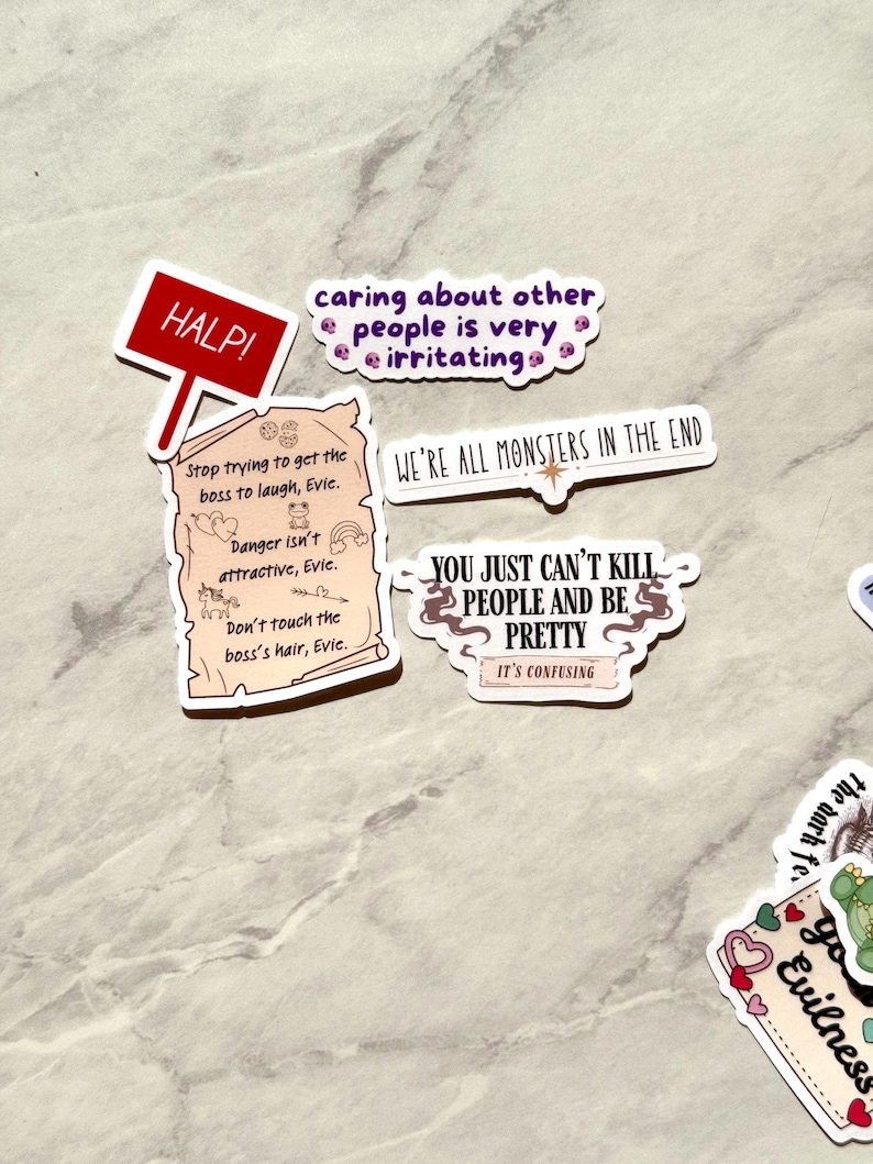 Puede incluir: Una colecci&oacute;n de pegatinas humor&iacute;sticas con varias frases y dise&ntilde;os. Una pegatina dice "HALP!" en un letrero rojo. Otras pegatinas incluyen frases como "caring about other people is very irritating" y "WE'RE ALL MONSTERS IN THE END."