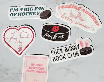 Op de afbeelding: Vijf stickers met een hockeythema. De stickers zijn roze, wit en zwart met verschillende tekst en afbeeldingen. De tekst op de stickers is: "Ik ben een grote fan van hockey", "Puck me", "Nog een hockeyroman lezen", "Mijn boekvriend speelt hockey" en "Puck Bunny Book Club".