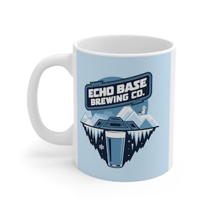 Puede incluir: Taza de cerámica blanca con fondo azul claro y diseño gráfico. El diseño presenta el texto "ECHO BASE BREWING CO." sobre una imagen estilizada de montañas, hielo y un vaso de cerveza. También se ve un oso polar.