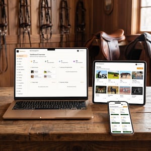 Puede incluir: Un portátil, una tableta y un teléfono inteligente que muestran un panel de control de gestión de establos en una mesa de madera. La pantalla del portátil muestra una descripción general del panel con datos. La tableta y el teléfono inteligente muestran información relacionada con los caballos.