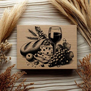 Op de afbeelding: Een zwart-witte illustratie van een stilleven met een brood, een stuk kaas, een tros druiven en een glas rode wijn op een houten oppervlak.
