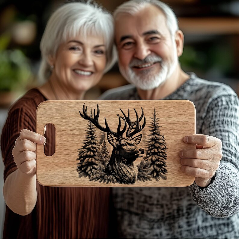 May include: A wooden cutting board with a black and white illustration of a deer in a forest setting. The board has a handle on the side.