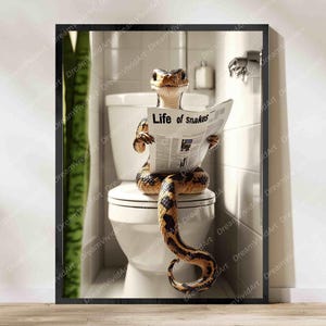 Könnte beinhalten: Ein gerahmter Wandkunstdruck, der eine braun-schwarz gemusterte Schlange zeigt, die auf einer weißen Toilette in einem gefliesten Badezimmer sitzt. Die Schlange hält eine Zeitung mit der Schlagzeile Life of snakes in fetter Schrift.