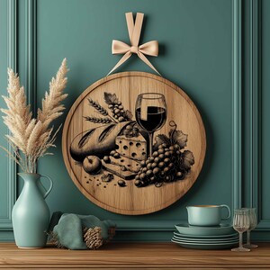 Op de afbeelding: Een ronde houten serveerschaal met een handgetekend ontwerp van een glas rode wijn, kaas, brood en druiven. De schaal is bruin en heeft een natuurlijke houtnerf.