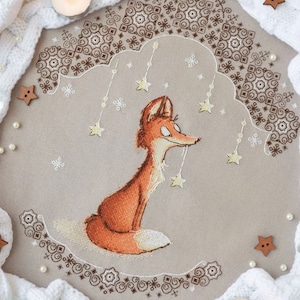 May include: A cross-stitch embroidery design featuring a fox sitting under a canopy of stars. The design is surrounded by a decorative border and is set against a beige background.