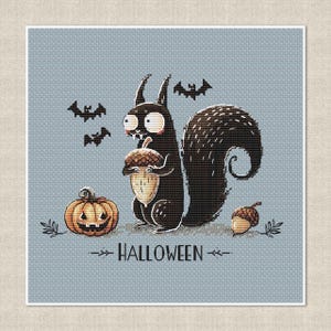 May include: A cross-stitch design featuring a black squirrel holding an acorn, a jack-o'-lantern, and bats against a light blue background. The word "HALLOWEEN" is displayed below the squirrel. The design has a whimsical, cartoonish style.