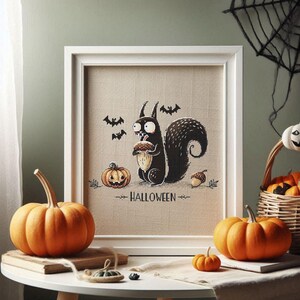 May include: A framed Halloween-themed cross-stitch featuring a black squirrel holding an acorn, with bats and pumpkins. The word "HALLOWEEN" is below the squirrel. Orange pumpkins and a basket of pumpkins are on a table.