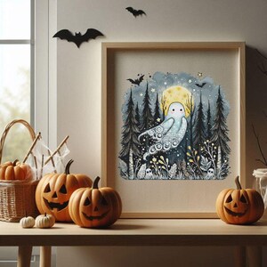 May include: A framed cross-stitch artwork featuring a whimsical ghost in a forest setting with a full moon. The artwork is displayed on a wooden table with carved pumpkins, a basket of pumpkins, and decorative bats, creating a Halloween theme.