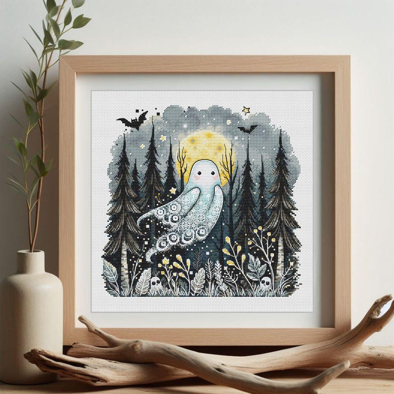 May include: A framed cross-stitch artwork featuring a whimsical ghost floating in a forest scene. The artwork includes a full moon, bats, and tall pine trees. The ghost is white with decorative patterns. The color palette includes shades of blue, yellow, and black.