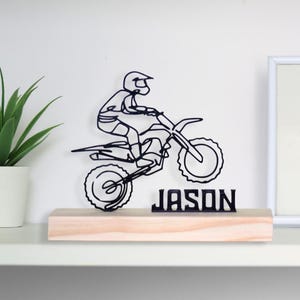 Escultura de piloto de motocross con base de madera