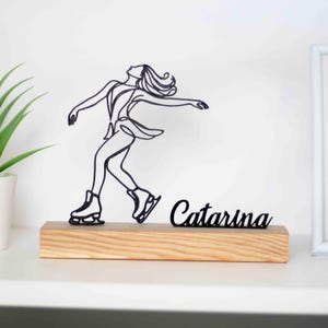 Escultura de patinador sobre hielo con base de madera