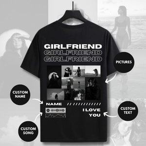 Puede incluir: Camiseta negra con las palabras "Girlfriend" repetidas tres veces en texto blanco. La camiseta también presenta un collage de fotos en blanco y negro, un icono de reproductor de música y el texto "I Love You".