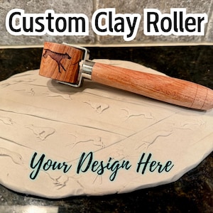 May include: A wooden clay roller with a design of a running dog on the roller. The roller is on a piece of white clay with the words "Your Design Here" written on it.