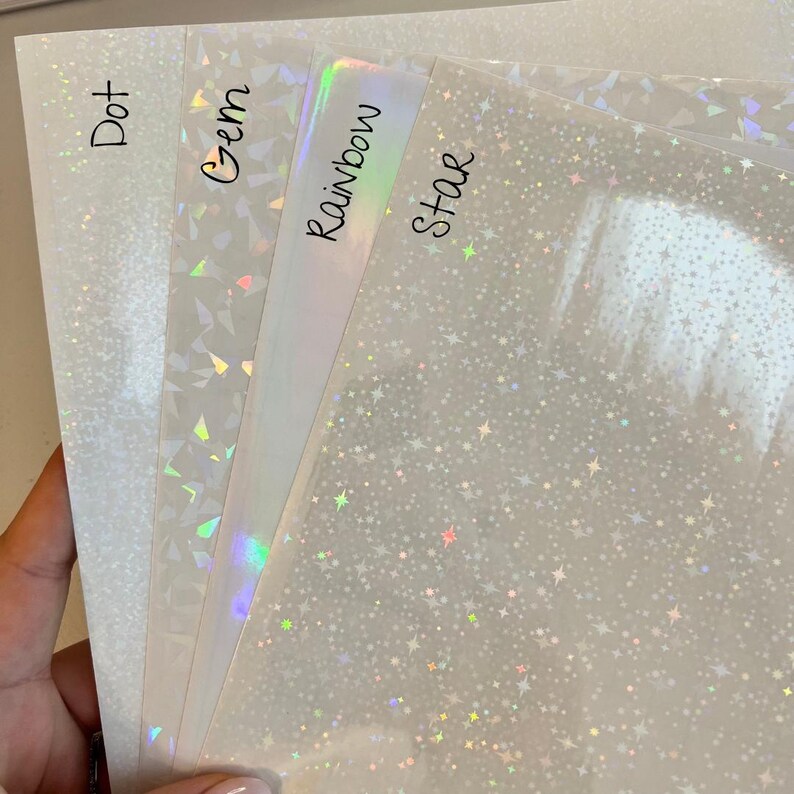 Puede incluir: Cuatro hojas de vinilo iridiscente con diferentes patrones: punto, gema, arco&iacute;ris y estrella. Las hojas son transl&uacute;cidas y tienen un brillo sutil.