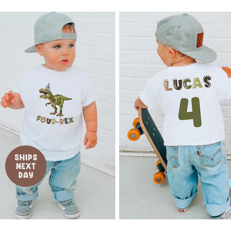 May include: A child wears a white t-shirt featuring a green dinosaur graphic and the text "FOUR-REX". The child is also wearing blue jeans and a grey baseball cap. The back of the shirt displays the name "LUCAS" and the number "4".