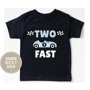 May include: Navy blue toddler t-shirt with a light blue race car graphic and the words "TWO FAST" in white. The race car has the number 2 on the side and two checkered flags. A fun shirt for a child's second birthday.