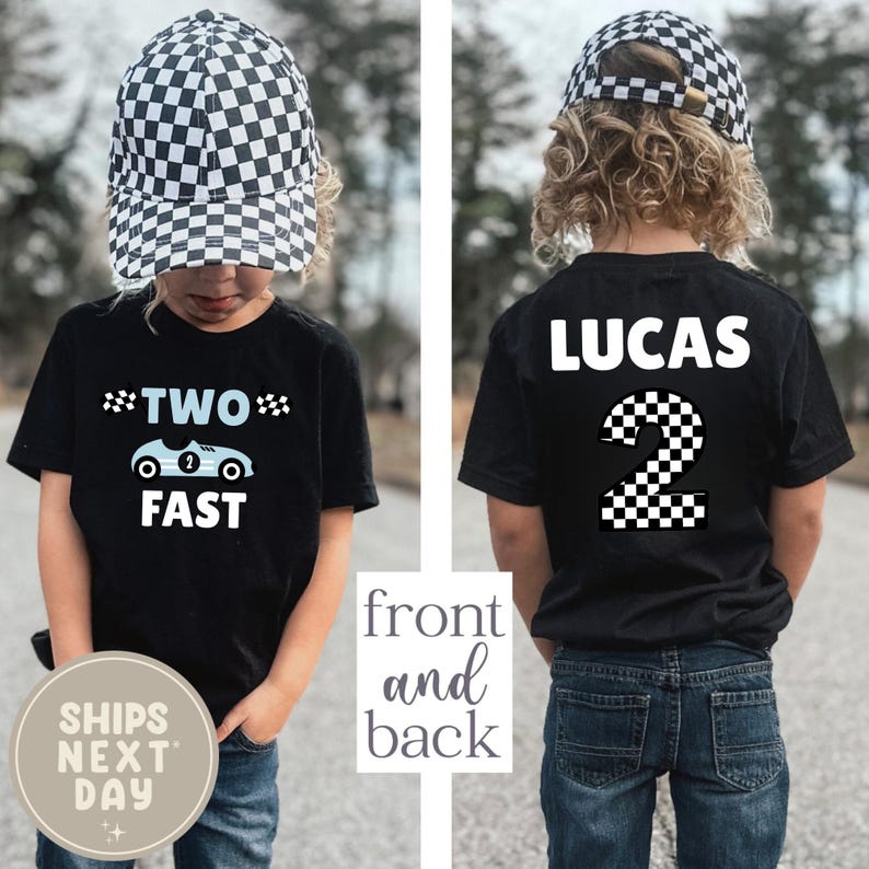 May include: Black t-shirt with "TWO FAST" and a race car graphic. The back of the shirt says "LUCAS" and has a checkered number 2. The child is wearing a black and white checkered hat. The shirt is for a two-year-old.