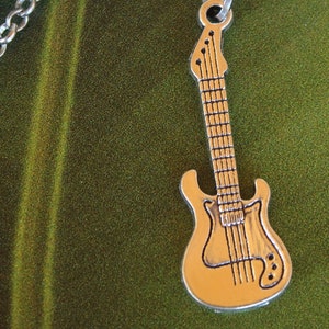 May include: A silver chain necklace with a silver guitar pendant. The guitar has a detailed design with strings and a pickguard.