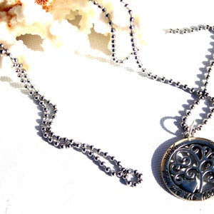 May include: A silver necklace with a round pendant featuring a tree of life design and the words "Know that you are the heart of everything".