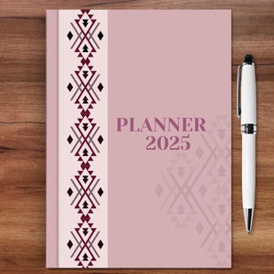 May include: A pink planner with a geometric pattern on the cover. The planner says "PLANNER 2025" on the front.