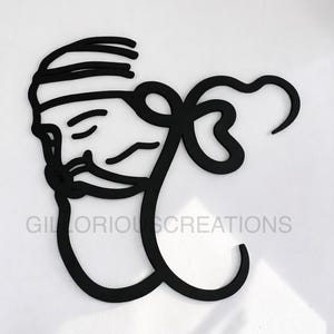 May include: Black metal wall art featuring a stylized face with a beard and head covering, combined with a decorative flourish. The text "GILLORIOUSCREATIONS" is displayed below the face. The artwork is mounted on a white wall.