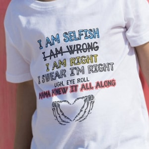 May include: White t-shirt with a colorful graphic print that says "I am selfish, I am wrong, I am right, I swear I'm right, Ugh, eye roll, Mama knew it all along". The graphic also includes a heart with skeleton hands.