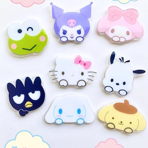 Peut inclure: Un ensemble de huit épingles de personnages de dessins animés colorés mettant en scène Hello Kitty, My Melody, Keroppi, Badtz-Maru, Cinnamoroll, Pompompurin et Tuxedo Sam. Les épingles sont en acrylique transparent et ont une finition brillante.