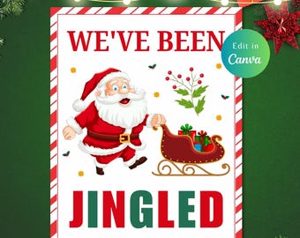 Puede incluir: Un cartel blanco con rayas rojas y verdes alrededor del borde. El cartel dice "We've Been JINGLED" en letras rojas y verdes. Una imagen de dibujos animados de Papá Noel tirando de un trineo lleno de regalos se encuentra en el centro del cartel.