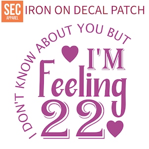 Puede incluir: Parche de calcomanía para planchar con texto rosa que dice "No sé de ti, pero me siento 22" con dos corazones rosas. El texto está en un círculo con las palabras "Iron on Decal Patch" en la parte superior.